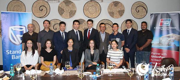 银联国际、南非标准银行工作人员与媒体合影。摄影王磊
